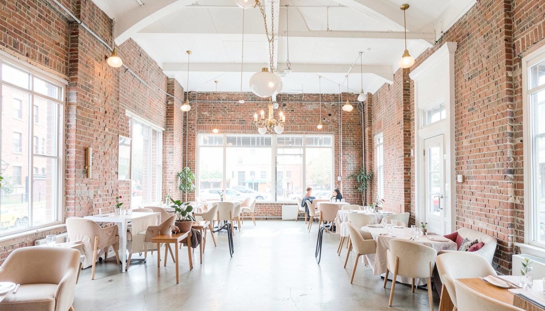 An urban downtown event space with exposed brick walls, high ceilings, and elegant pendant lighting, blending industrial charm with modern style